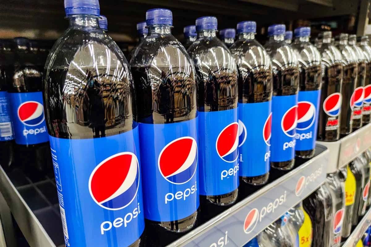 Botellas de Pepsi con etiquetas azules alineadas en una góndola